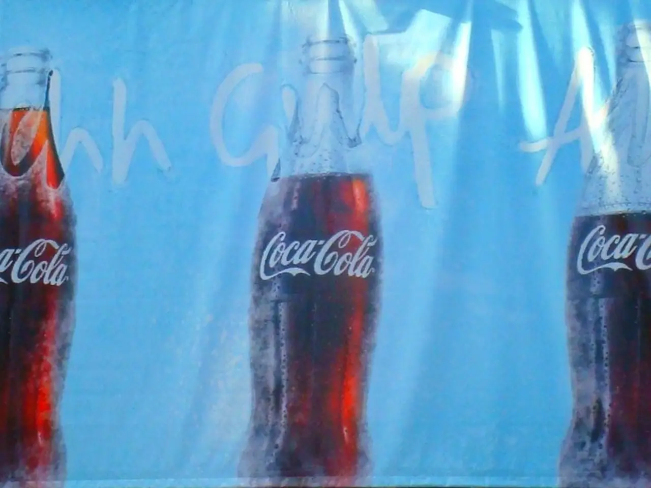 There are three coca cola bottles printed on a cloth.
