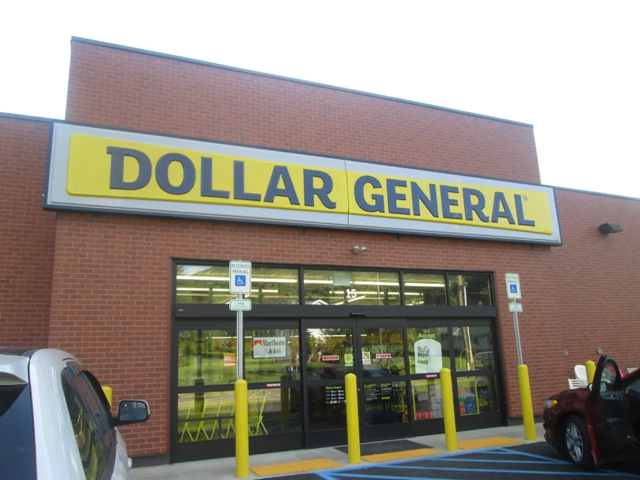 There is a store and in front of the store there are two cars parked on a road,the wall of the...