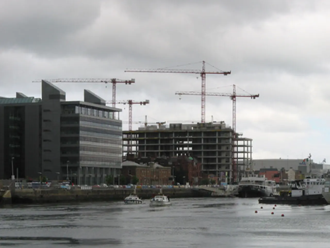 In this image there is a river, on that river there are ships, in the background there is a bridge,...