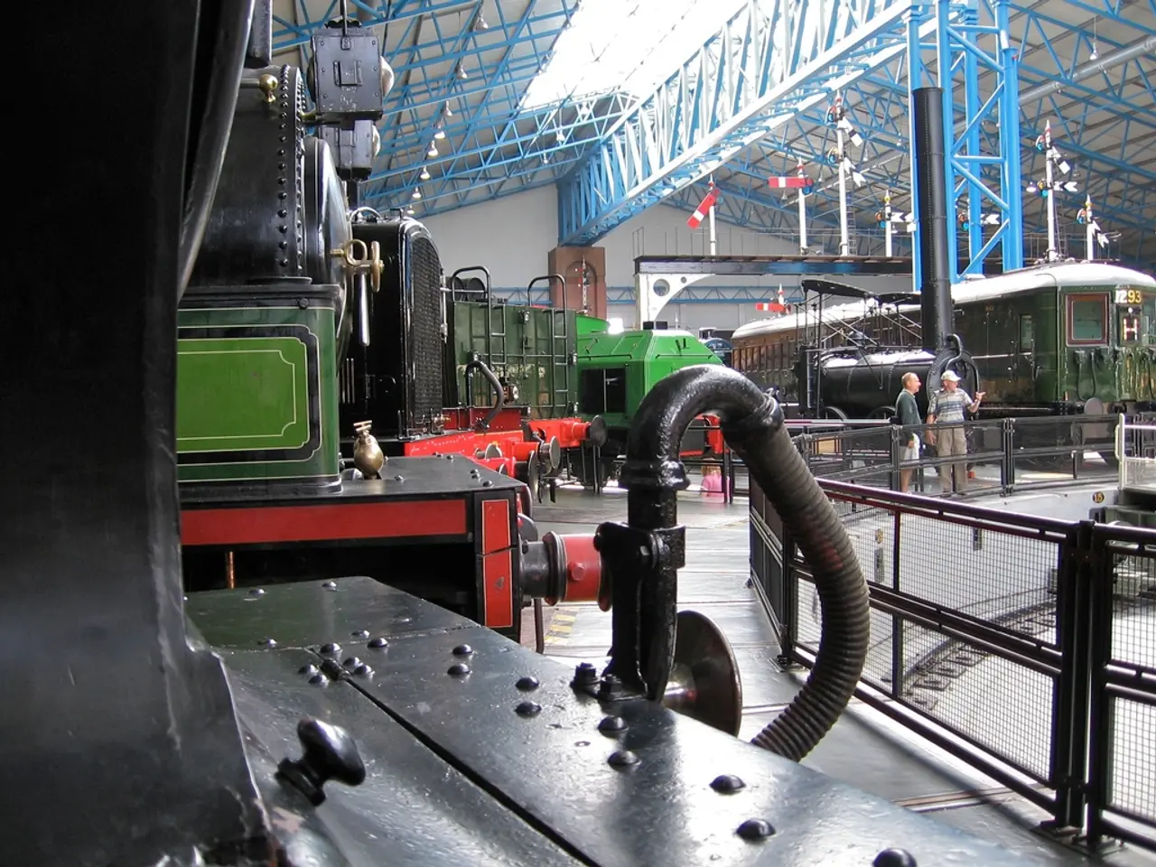 In this image there are train engines in the go down. At the top there are so many iron rods. On...