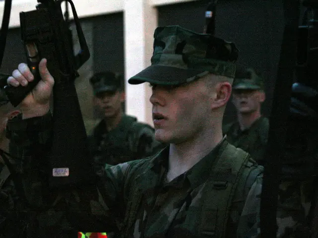 In this image we can see people standing and holding rifles. They are wearing uniforms. In the...