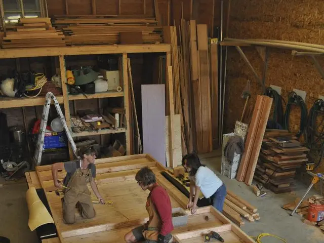 In this picture we can see a carpentry workshop with people working inside it.