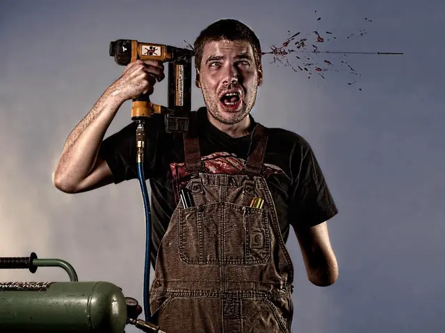 In this image there is a man standing and holding a drilling machine in his hand. On the left side...