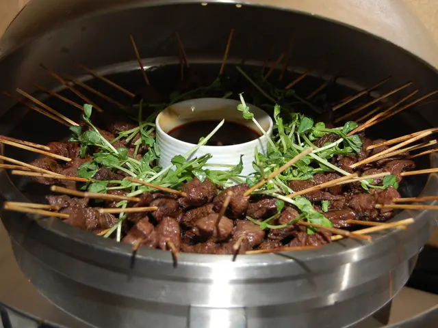 In a dish there is a cooked food item and to each of the food item there is a stick inserted into...