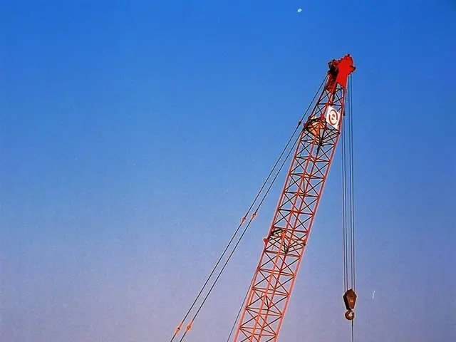 In the image we can see there are buildings and there are two cranes kept on top of the building....