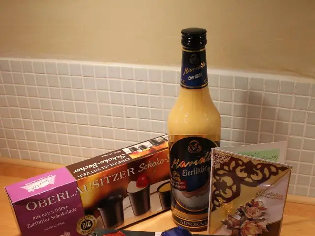 In the image there is a diary,some pencils,cookies, a drink and a greeting card are kept in front...